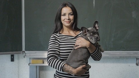 Lehrerin Julia während ihres Unterrichts in der Schule mit Therapiehund Ruby auf dem Arm