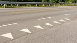 Haifischzähne als Markierung auf dieser Straße sind ein Verkehrszeichen für die Anzeige der Vorfahrt.