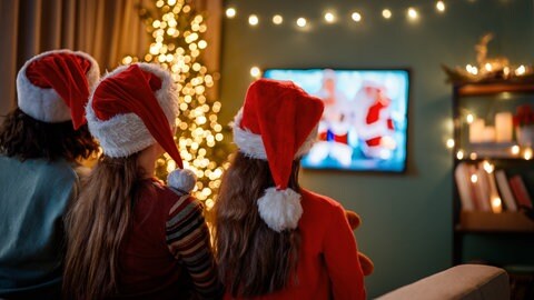 Eine Familie schaut Klassiker der Weihnachtsfilme im TV.