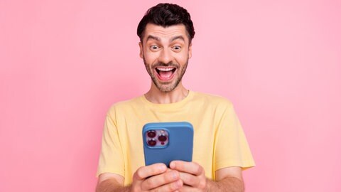 Ein junger Mann vor roas Hintergrund macht am Handy den lustigen Selbsttest zum Thema Handysucht und Digital Detox.