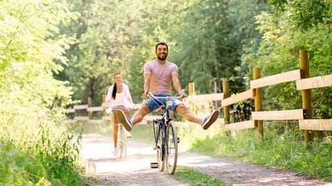Ein Mann fährt auf einem Fahrrad durch den Sommer.