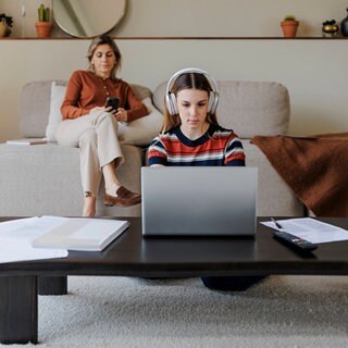Eine Frau sitzt mit ihrem Smartphone auf dem Sofa, ein junges Mädchen sitzt mit einem Laptop am Schreibtisch. Ob beide gerade etwas lernen oder nur kurz mit Google und KI recherchieren? Oder ob sie die Tipps vom Lernforscher kennen?