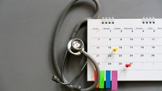 Ein Kalender mit Stetoskop steht symbolisch für die Frage: Darf ich während der Arbeit zum Arzt? 
