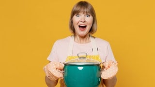 Eine Oma hat in einem großen Topf Hühnersuppe bei Erkältung gekocht. 